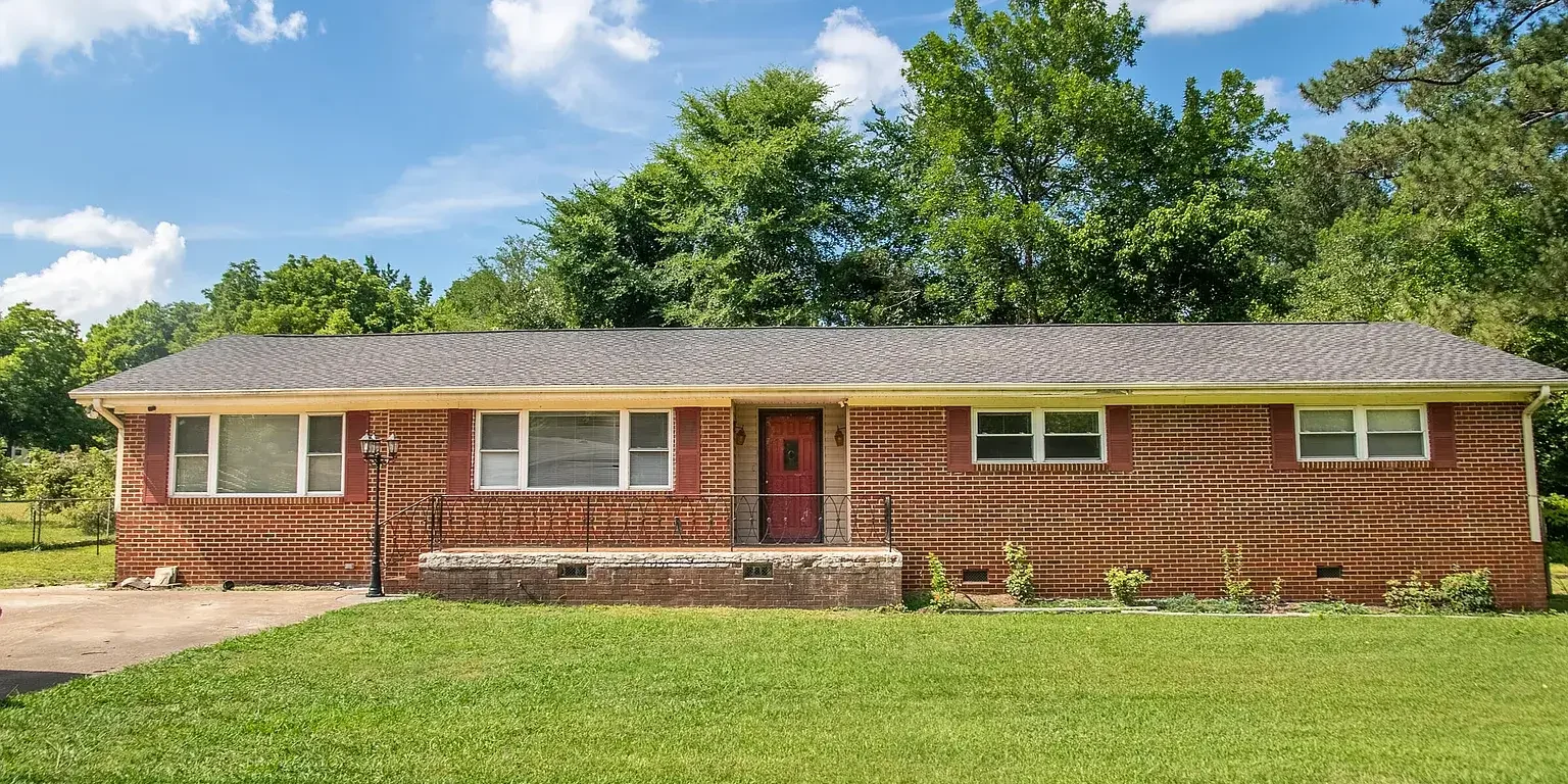A house with grass and trees in the background.