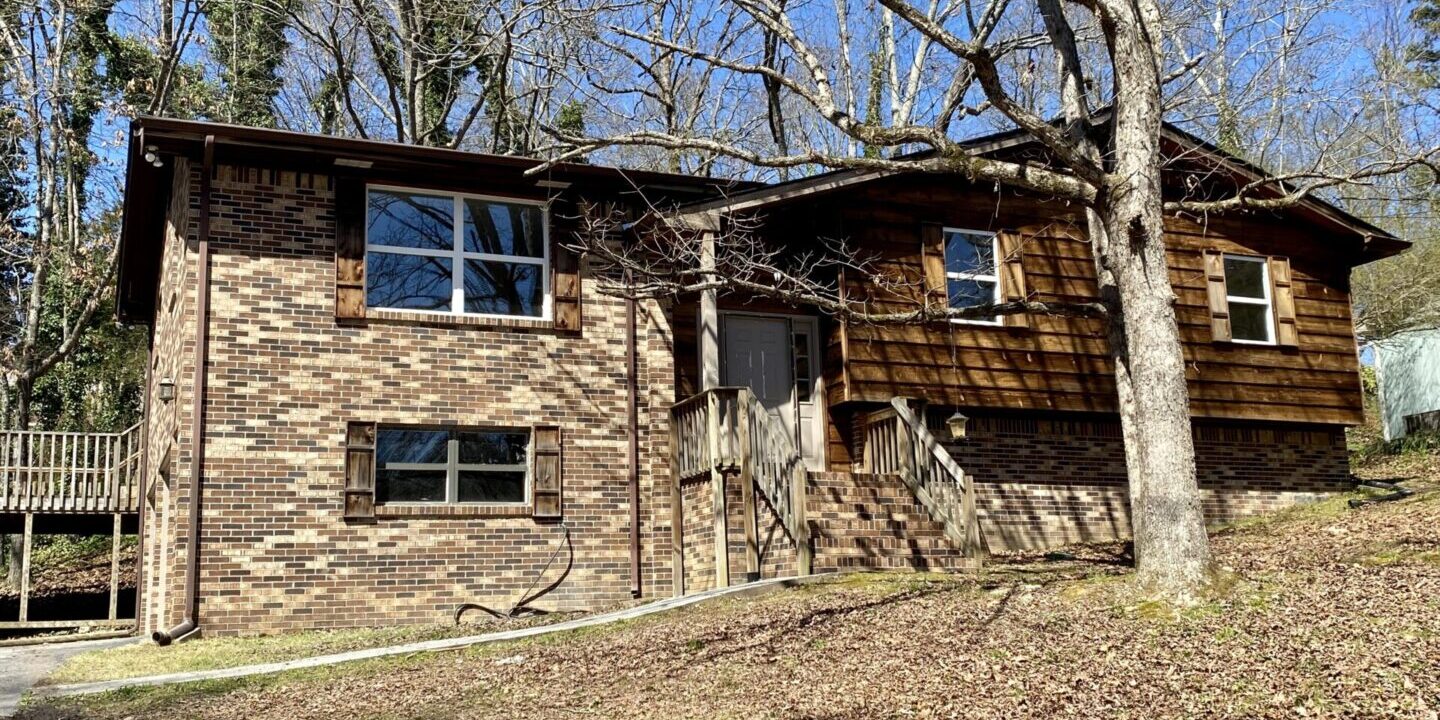 A brick house with trees in the background