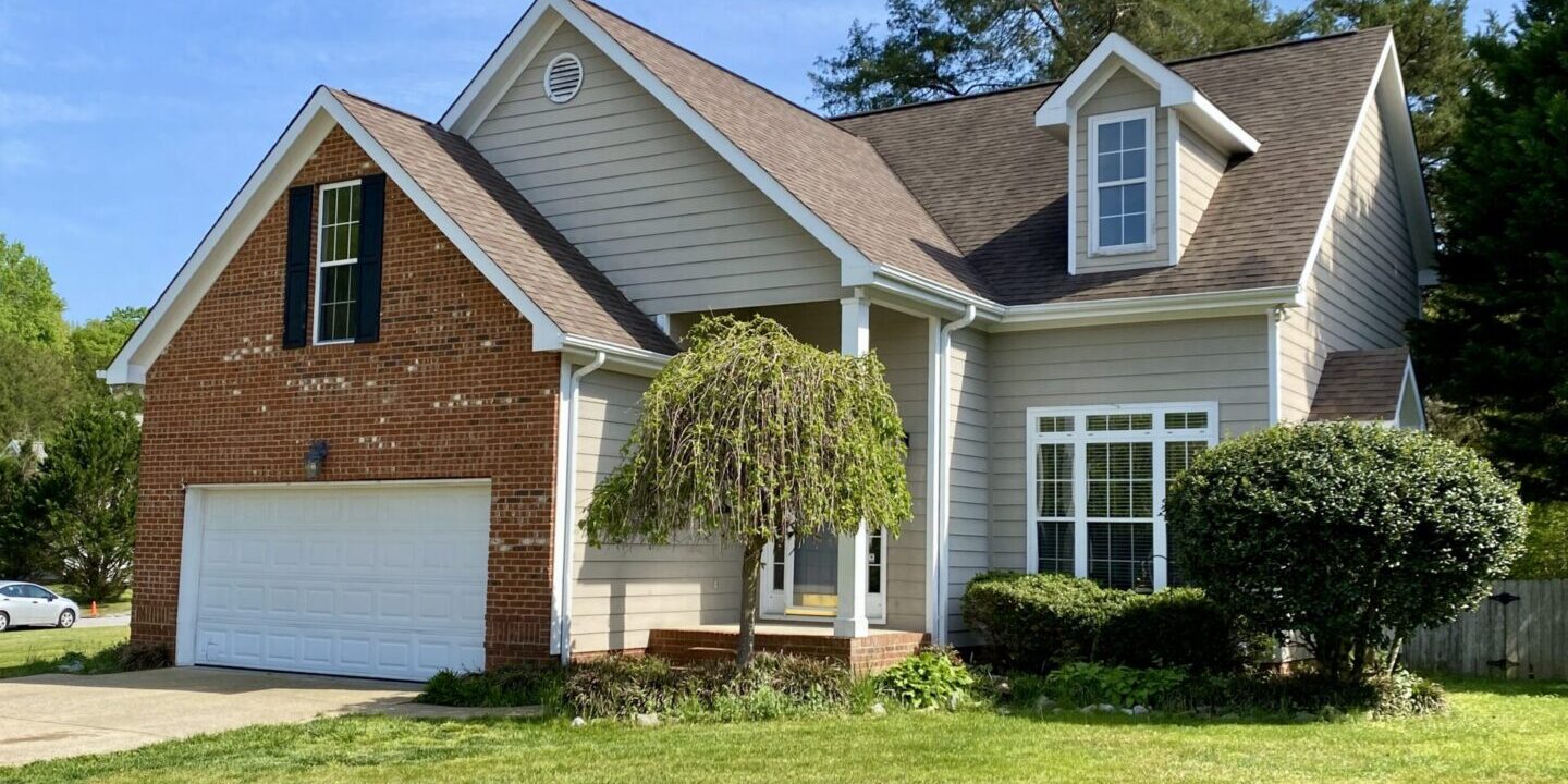 A house with a garage and trees in front of it