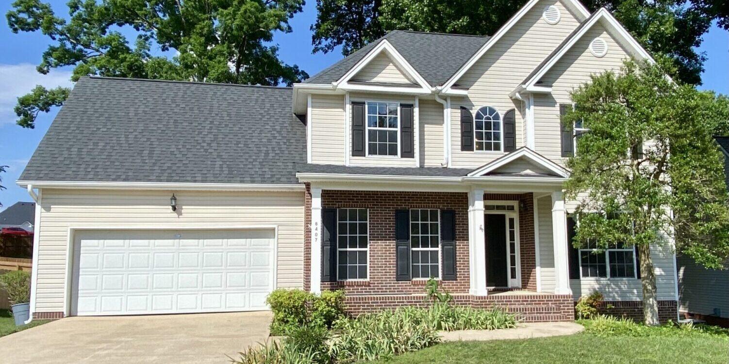 A house with a driveway and garage in front of it.