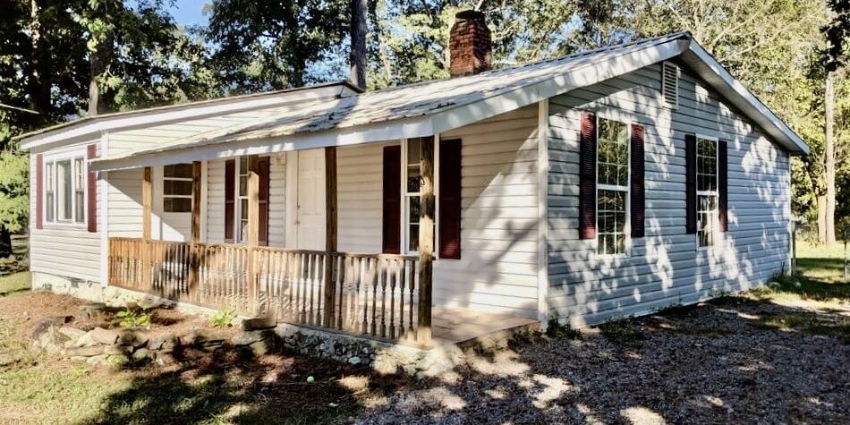 Sunlit vinyl-sided house with wooden porch
